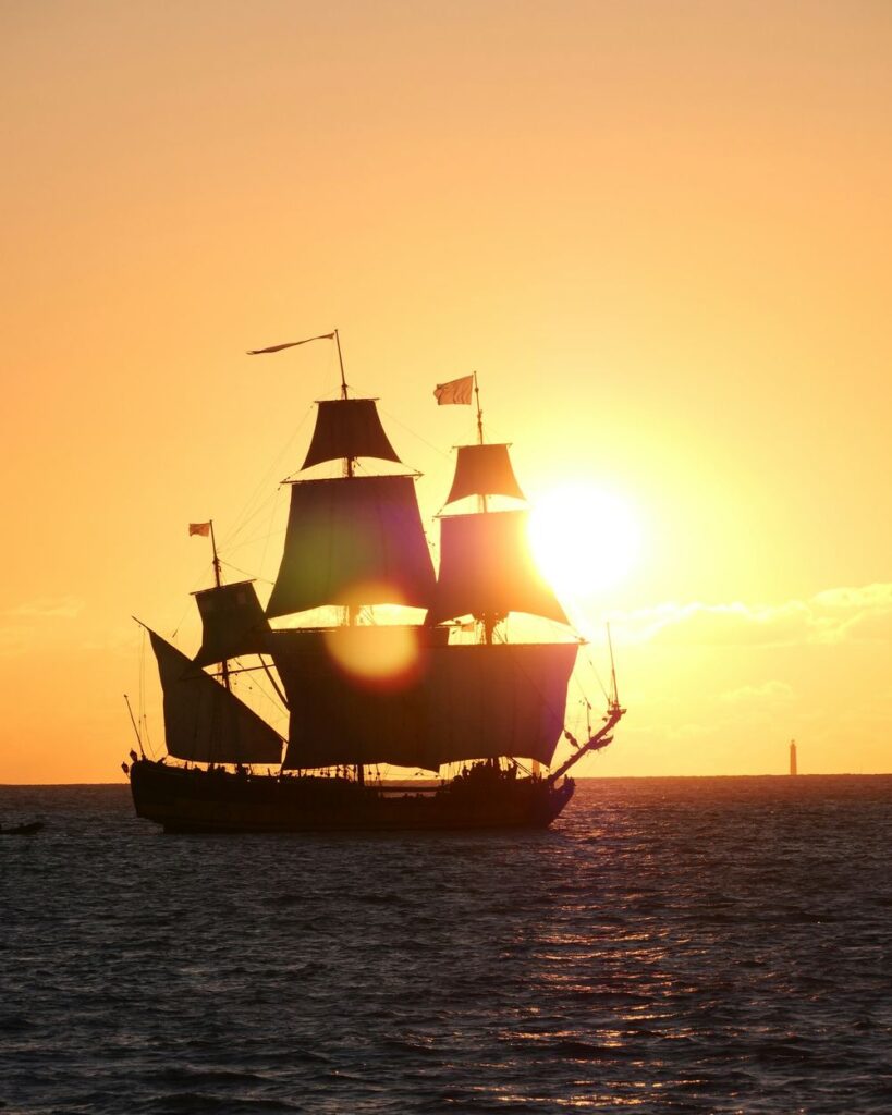 Velero de época a contraluz en el atardecer