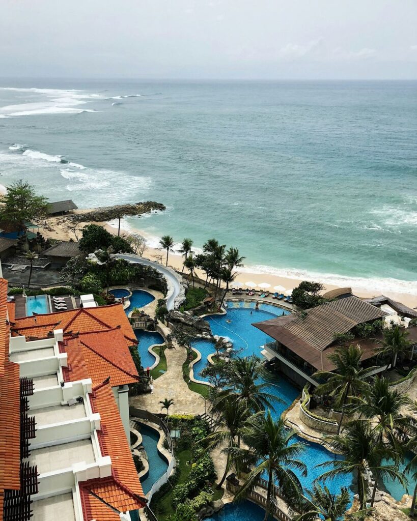 Vista aérea de un hotel con piscinas junto a la playa